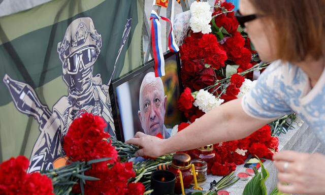 Anhänger des mutmaßlich bei einem Flugzeugabsturz ums Leben gekommenen russischen Söldnerführers Jewgenij Prigoschin trauern. Hier legt eine Frau in Moskau Blumen an einer improvisierten Gedenkstätte nieder. 