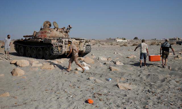Fighters of Libyan forces allied with the U.N.-backed move from a beach after they fire shells with Soviet made T-55 tank at Islamic State fighters in Sirte