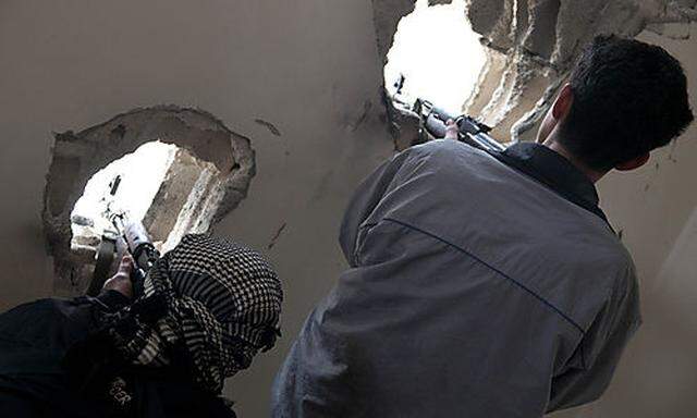 In this photo taken on Monday Dec. 19, 2011, defected Syrian soldiers position their rifles as they t