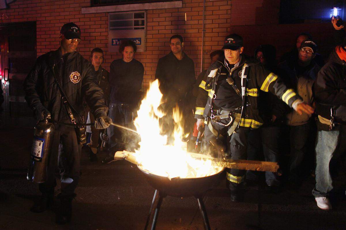 Lower East Side, New York. Feuerwehrleute löschen ein Feuer, an dem sich Anrainer wärmen wollten.