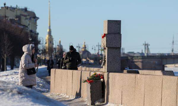 A person comes to lay flowers at the monument to the victims of political repressions to honour the memory of Russian opposition leader Alexei Navalny, in Saint Petersburg, Russia, February 18, 2024. REUTERS/Stringer