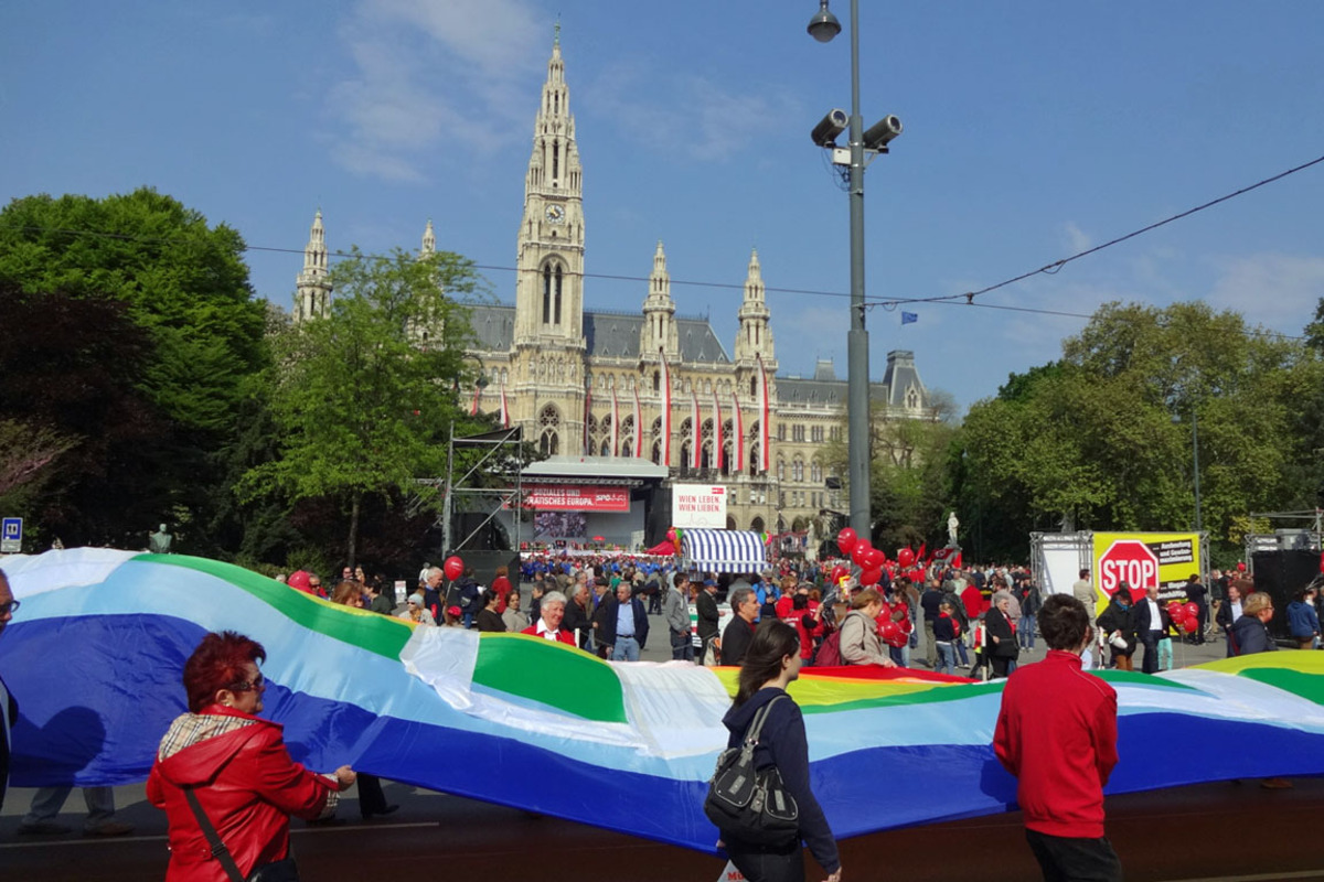 Im Zeichen des Friedens und der sozialen Gerechtigkeit - und ausgerüstet mit einer überdimensionalen Peace-Fahne - zieht es diese Truppe auf den Rathausplatz.