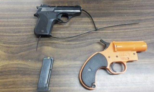 A .22 caliber handgun, its magazine and a flare gun seized by police from a seven-year-old boy at Wave Prep School in New York are pictured in this handout photo