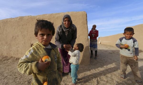 Children eat fruits in Ghazila village after fighters from the Democratic Forces of Syria took control of the town from Islamic State forces in the southern countryside of Hasaka