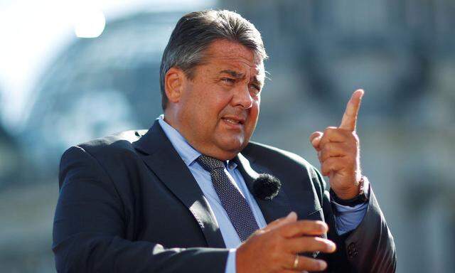 German Economy Minister Sigmar Gabriel arrives for a television interview in front of the Reichstag building in Berlin