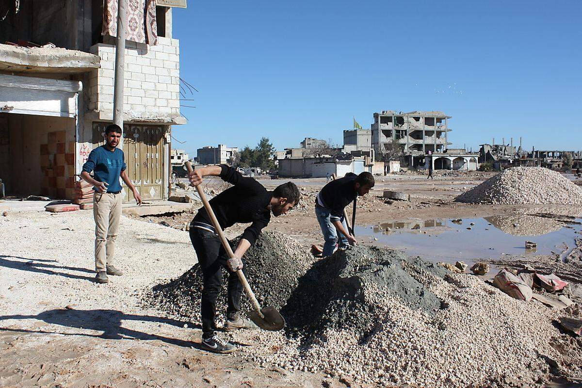 Die türkische Blockade bringt Probleme für den Wiederaufbau. Zement darf nicht offizell über die Grenze. Er kann nur über Umwege nach Kobane gebracht werden. Trotzdem haben die ersten Arbeiten begonnen, um die zerstörte Stadt neu entstehen zu lassen.
