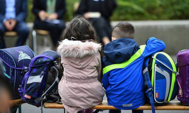 Erster Schultag in Nordrhein-Westfalen Zwei Schulkinder sitzen mit ihren Tornistern auf einer Bank vor der Schule. In No