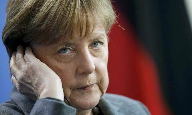 German Chancellor Merkel adjusts her earphones during news conference at the Chancellery in Berlin