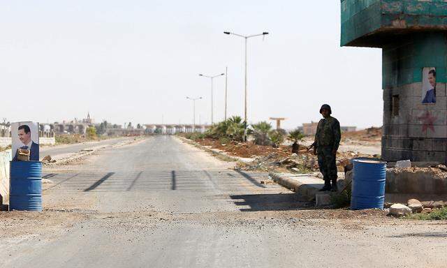 A Syrian soldier stands guard at the Nasib border crossing with Jordan in Deraa
