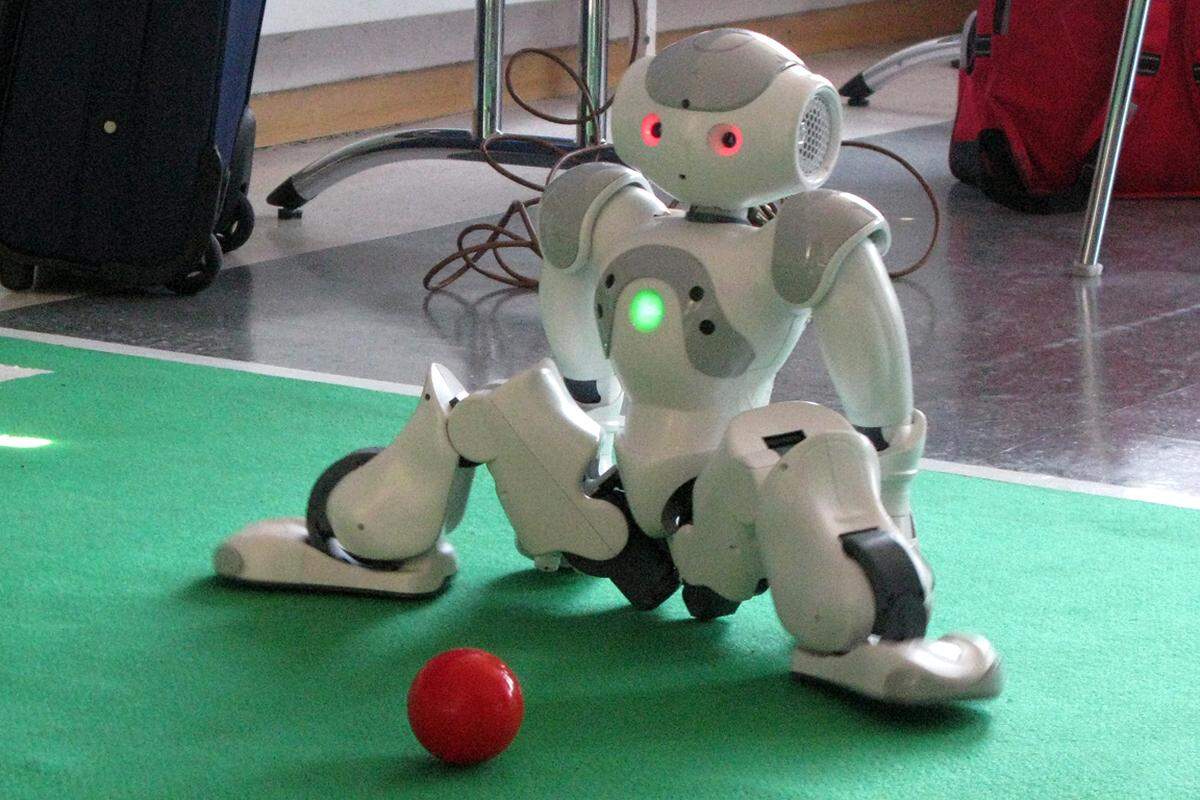 Außerdem wird die kleinste Falte im Teppich zum Hindernis - bei der Demo stürzte der kleine Roboter häufiger als er den Ball trat. Immerhin: Aufrichten kann er sich selbstständig und widmet sich dann sofort wieder seiner Aufgabe.