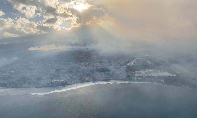 Rauch steigt über verbranntem Gebiet auf der Insel Maui auf.