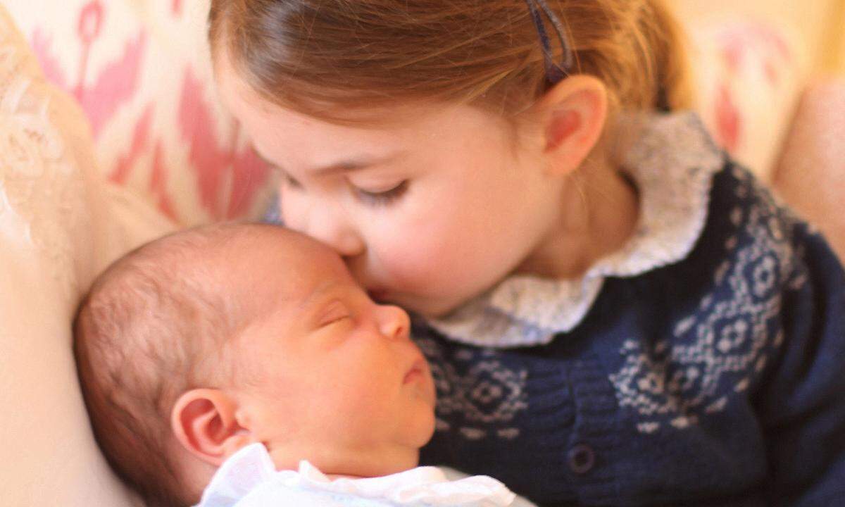 Auf einem der ersten offiziellen Bilder des Nachwuchses wird der kleine Prinz von seiner Schwester, Prinzessin Charlotte, auf die Stirn geküsst.
