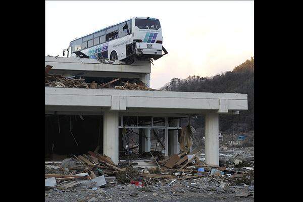 Fast zwei Wochen nach der Katastrophe liegt in Ishinomaki am Donnerstag immer noch ein Autobus auf einem Dach.