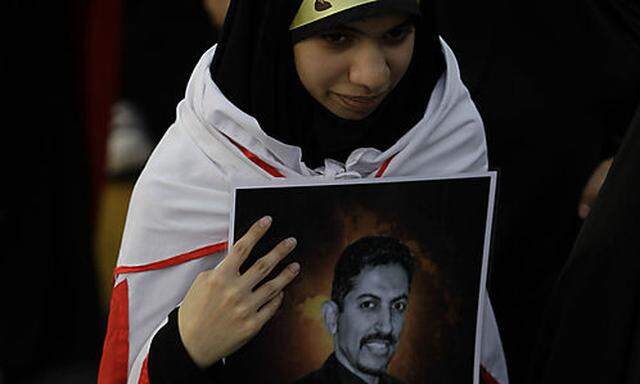 Eine Demonstrantin mit dem Porträt Abdulhadi al-Khawajas