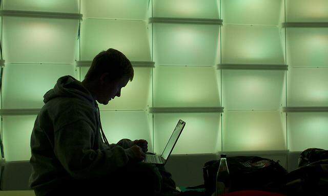 Woman uses computer in lounge area of Chaos Communication Congress (25C3) in Berlin