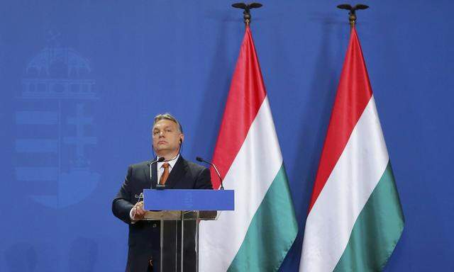 Hungarian Prime Minister Orban listens as German Chancellor Merkel addresses news conference in Budapest