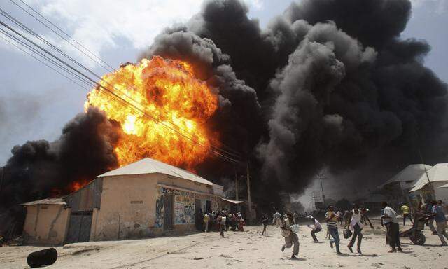 People run away from an explosion at a petrol station and storage facility near the Bakara open-air market in Somalia´s capital Mogadishu