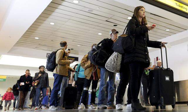 Travelers wait in line at a security checkpoint at La Guardia Airport in New York