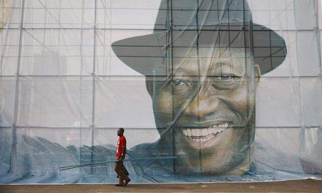 A man walks past a portrait of Nigeria´s President Jonathan, who began his campaign on Wednesday for a second-term in office in Lagos