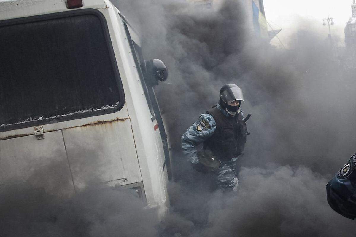 Auch nicht zimperlich: Demonstranten griffen einen Polizeibus mit Rauchbomben an.