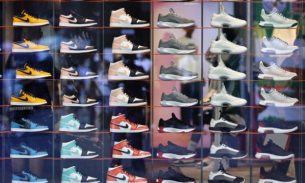 Sneaker verschiedener Schuhhersteller wie Nike stehen in einem Schaufenster. 