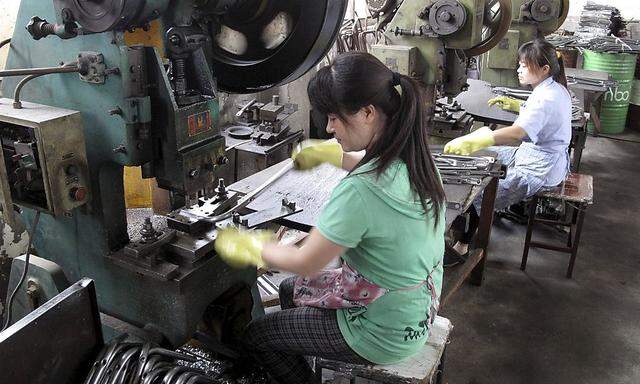 Workers make metal parts at a factory of the Changzhou Wujin Zhengda Vehicle Industry Co. Ltd in Changzhou