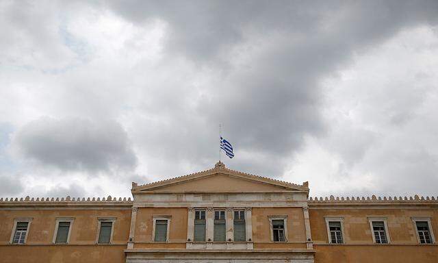 A Greek national flag flies at half mast over the parliament building as a period of national mourning is declared for the victims of wildfires, in Athens