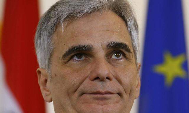 Austrian Chancellor Faymann listens during a news conference after a cabinet meeting in Vienna