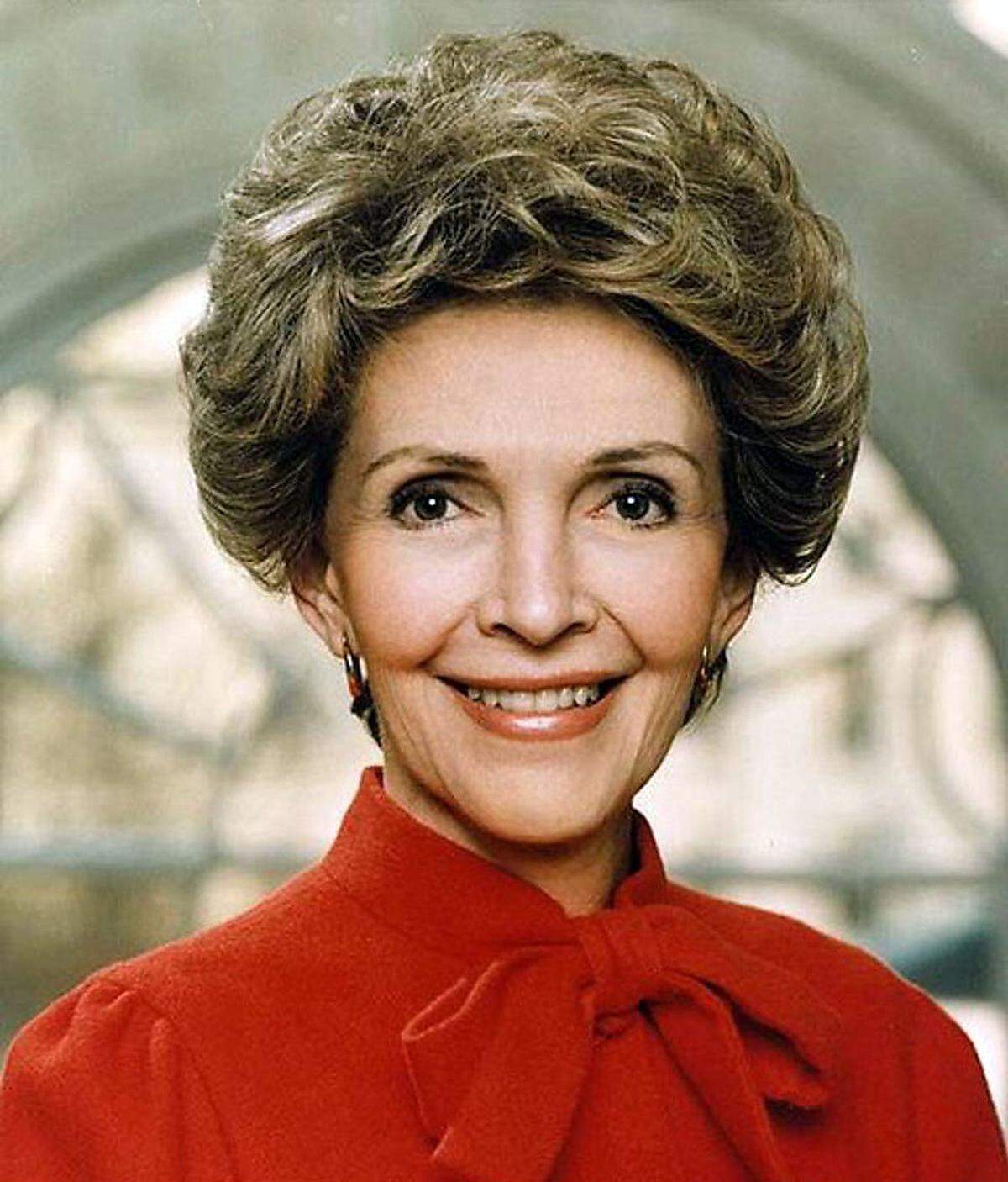 ...Nancy Reagan. Sie war von 1981 bis 1989 First Lady der USA, und das Foto, das Melania Trump inspierert haben dürfte, stammt aus dem Jahr 1983. Wie Trump trug auch Reagan auf dem Foto eine Bluse mit Schleife und posierte vor demselben Fenster. Reagan war als erste Dame im Lande bekannt für ihren sehr konservativen Kleidungsstil - und für ihre äußerst konservative Haltung in den Bereichen Familie oder Homosexualität gegenüber.