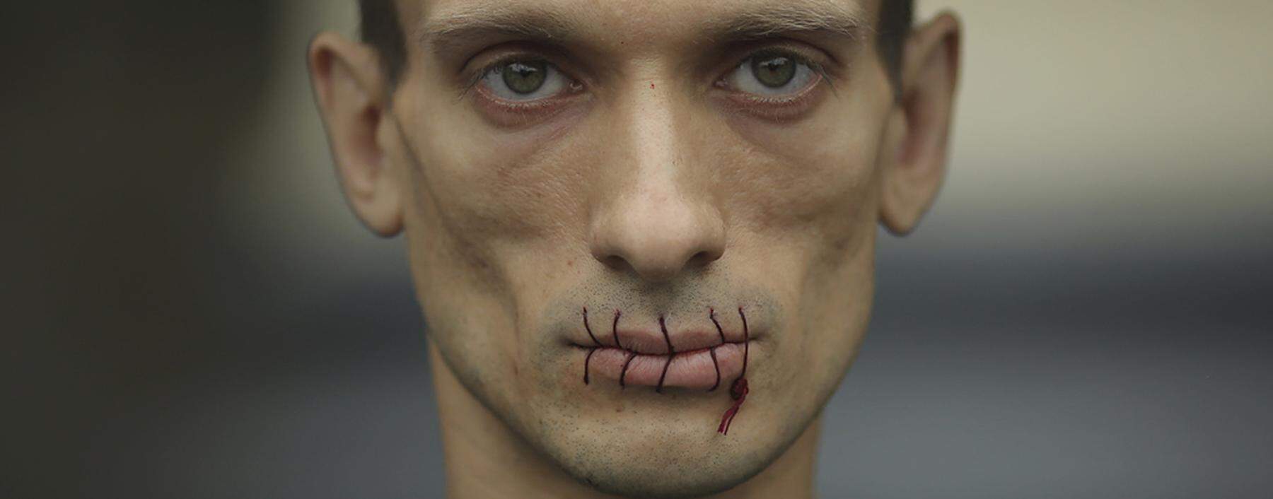 Artist Pavlensky, a supporter of jailed members of female punk band ´Pussy Riot´ looks on with his mouth sewed up as he protests outside the Kazan Cathedral in St. Petersburg