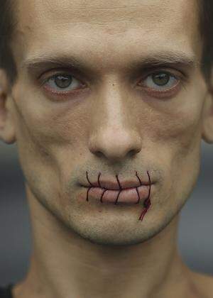 Artist Pavlensky, a supporter of jailed members of female punk band ´Pussy Riot´ looks on with his mouth sewed up as he protests outside the Kazan Cathedral in St. Petersburg