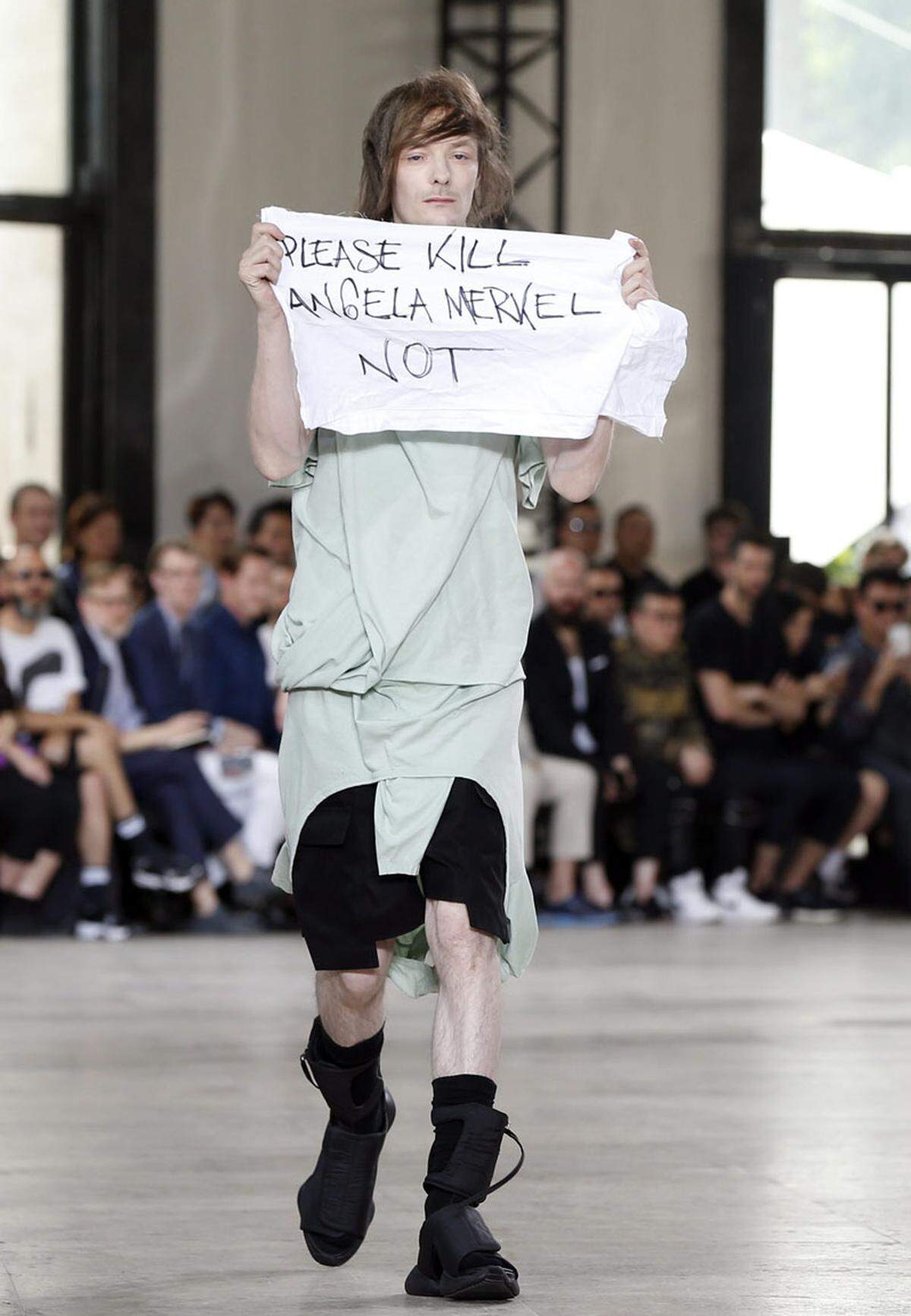 Für Aufregung sorgte das Model Jera Derac bei der Show von Rick Owens bei der Pariser Männermodeschau im Palais de Tokyo. Auf dem Catwalk zog er ein Stück Stoff hervor, auf dem "Please Kill Angela Merkel - Not" stand.