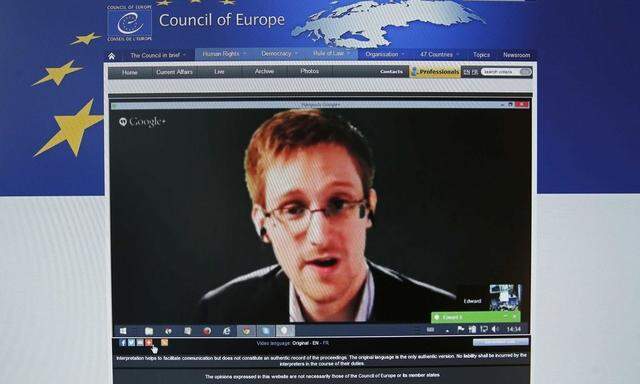 File photo of accused government whistleblower Snowden seen on the computer screen of a journalist as he speaks via video somewhere in Moscow