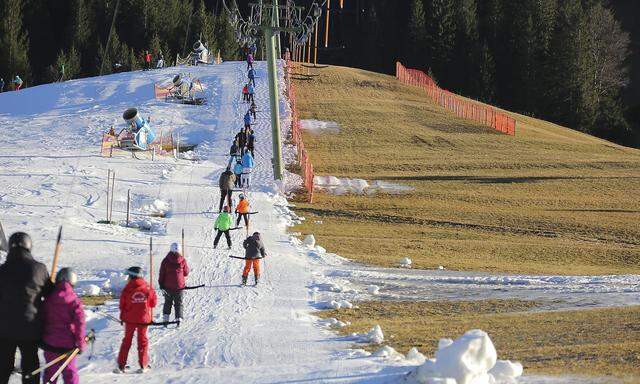 Wanderer Gleitschirmflieger und Skifahrer sind unterwegs bei warmen Temperaturen und Schneemangel t