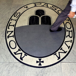 A man walks on a logo of the Monte Dei Paschi Di Siena bank in Rome