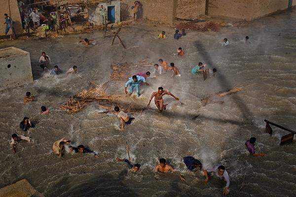 Daniel Berehulak, Australien, Getty Images  Flut in Pakistan: Bewohner eines überfluteten Gebietes versuchen am 13. September, an Essenspakete zu kommen, die Armee-Hubschrauber abwerfen