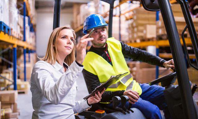 Young warehouse workers working together.