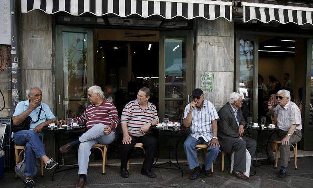 People sit at a cafe in Athens