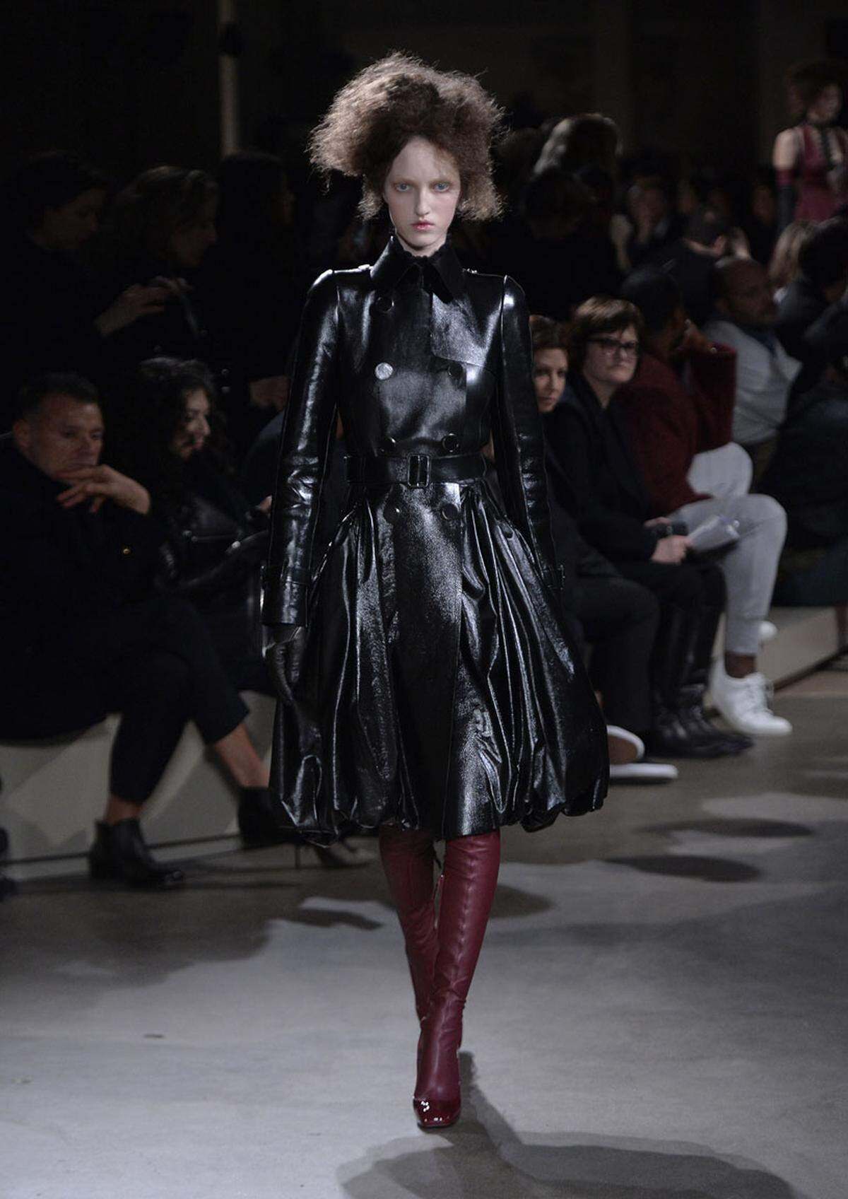 Schwarzer Mantel zu roten Stiefel. Ganz in Leder ist dieser Look von Alexander McQueen gehalten. 