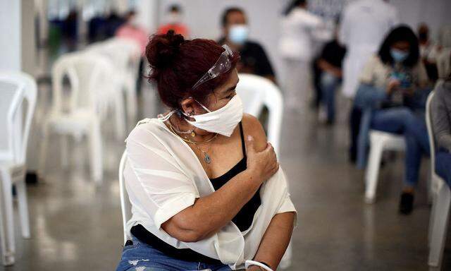 A woman holds her arm after receiving a dose of Pfizer-BioNTech coronavirus disease (COVID-19) vaccine at a vaccination center as the Salvadoran government authorized a fourth dose of the vaccine in San Salvador , El Salvador, March 22, 2022.