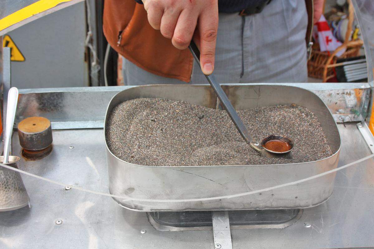 Kaffee wird mit traditioneller Methode durch Rühren im glühend heißen Sand erhitzt.