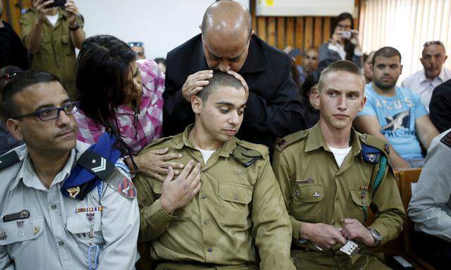 Der verurteilte israelische Soldat Elor Asaria (Mitte) wird von seinem Vater getröstet.