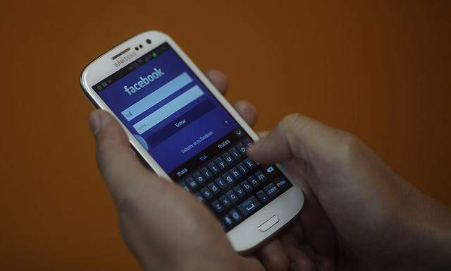 A smartphone user logs into his Facebook account in Rio de Janeiro