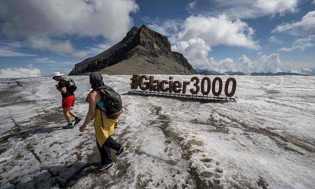 Touristen spazieren auf dem Zanfleuron-Gletscher oberhalb des Orts Les Diablerets in der Schweiz.
