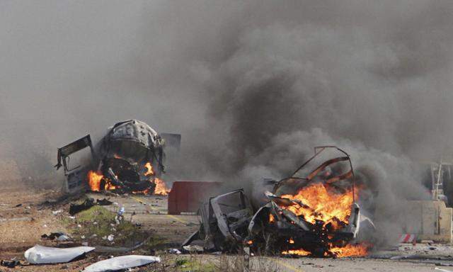 Burning vehicles are seen near the village of Ghajar on Israel´s border with Lebanon
