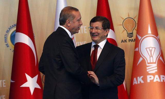Turkey's President-elect Erdogan shakes hands with incoming PM Davutoglu during the Extraordinary Congress of the ruling AK Party (AKP) in Ankara