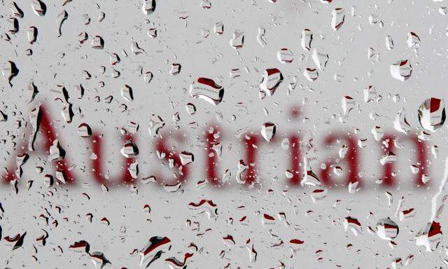 The logo of Austrian Airlines (AUA) is pictured through raindrops on a window at its headquarters in Schwechat