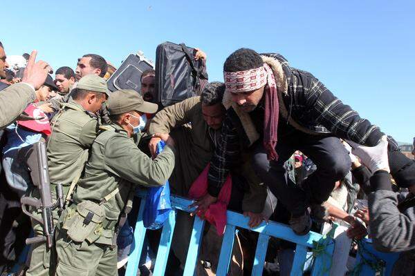 Eine Handvoll tunesischer Polizisten und Soldaten steht am Grenzübergang Ras Jedir und versucht, den Übertritt Tausender zu regeln - sie sind überfordert.