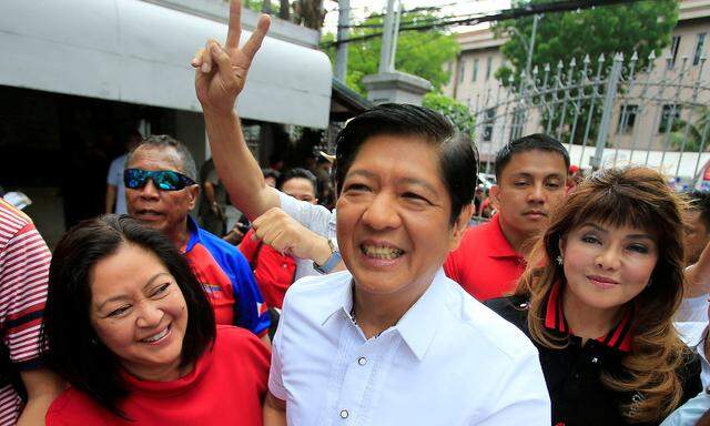 FILE PHOTO: Ferdinand 'Bongbong' Marcos, son of late dictator Ferdinand Marcos, his wife, Louise (L) and his sister Imee (R) smile upon arrival at the Supreme Court in Padre Faura