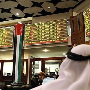 Investors look at stock exchange information at the Dubai Financial Market
